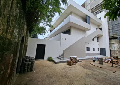 Façade blanche à balcons sculptés, immeuble ACOBAT en Zone 4, Abidjan